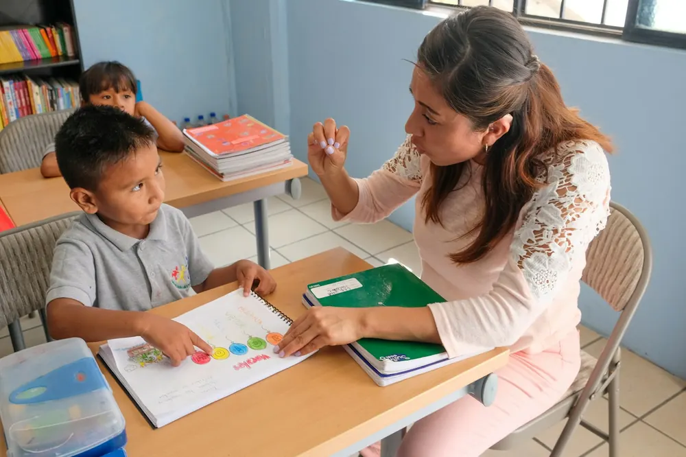 Un'insegnante aiuta un bambino durante un'attività in classe