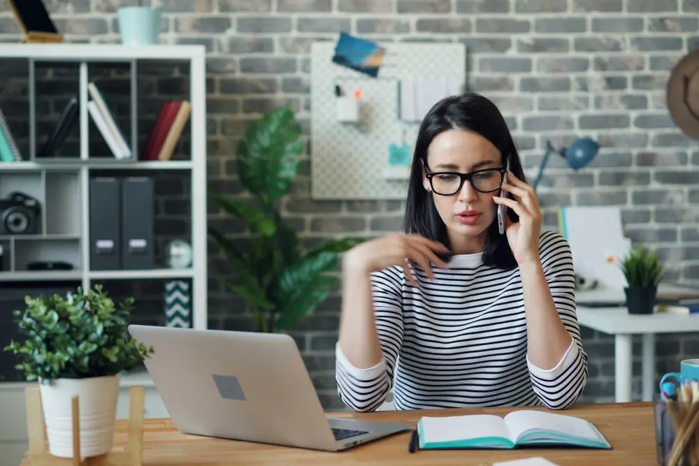 Un'impiegata al telefono alla scrivania con il computer