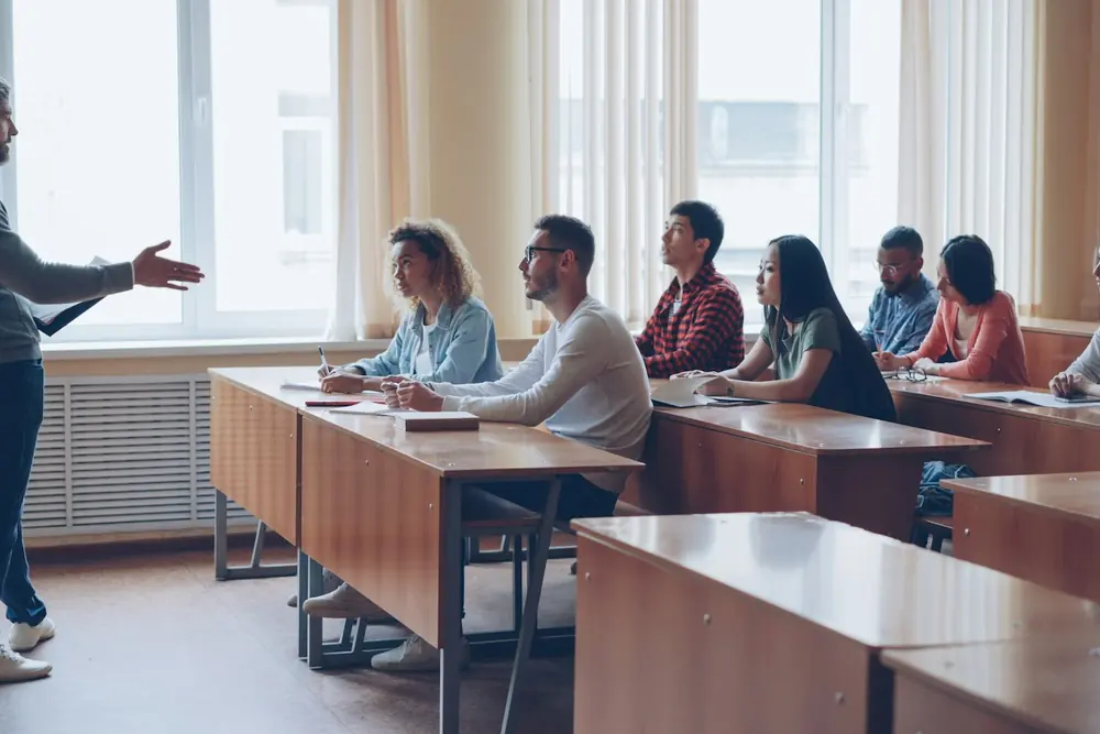 Adulti in aula durante una lezione con il docente