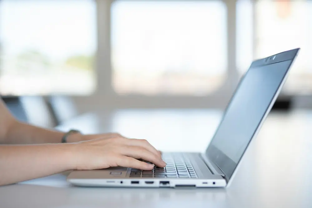 Mani che scrivono sulla tastiera di un computer portatile